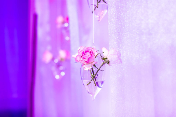 colgando decoración de la boda del partido sobre fondo rosa, flores en un jarrón de cristal de forma de gota
 - Foto, imagen
