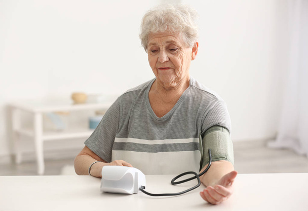 Bejaarde vrouw bloeddruk meten - Foto, afbeelding