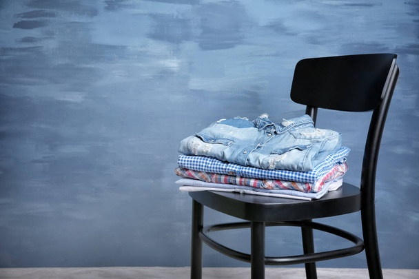 Pile of clothes on wooden chair - 写真・画像