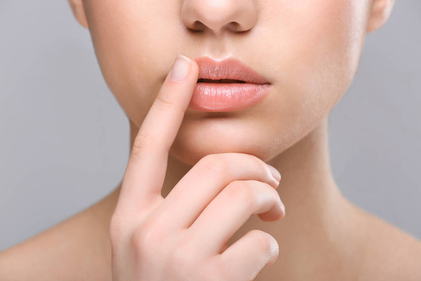 Woman with cold sore touching lips - Photo, image