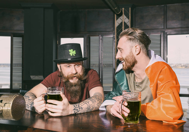 Men celebrating Saint Patrick's Day in pub - Фото, зображення