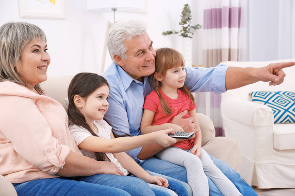 Gelukkig familie kijken TV op de bank thuis - Foto, afbeelding