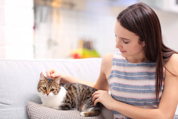 Beautiful young woman with cute cat at home - Fotoğraf, Görsel