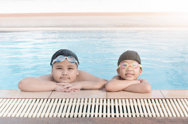süße asiatische Mädchen und Fett junge Lächeln im Schwimmen  - Foto, Bild