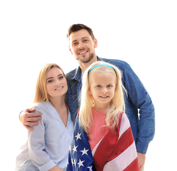 Cute girl wrapped in USA flag with parents behind - Zdjęcie, obraz