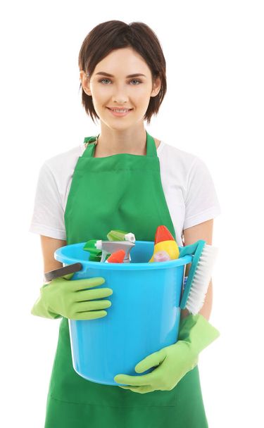 Young woman holding bucket with cleaning supplies on white background - Valokuva, kuva
