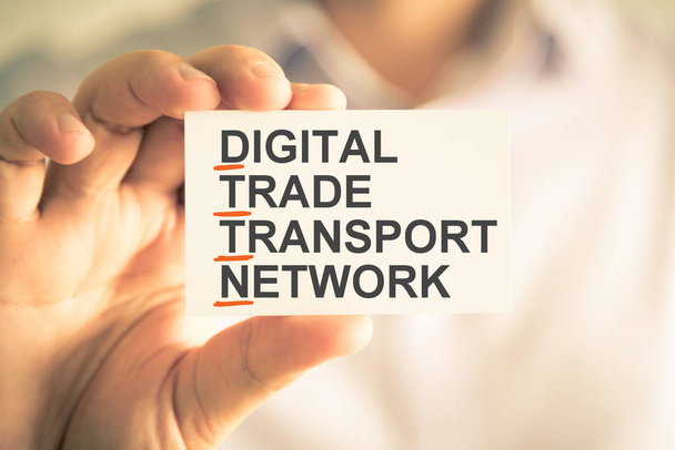 Επιχειρηματίας κρατώντας την κάρτα με το Dttn ψηφιακό δίκτυο μεταφορών εμπόριο αρκτικόλεξο κείμενο - Φωτογραφία, εικόνα