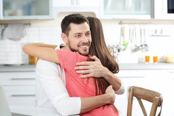 Young couple embracing at kitchen - Foto, afbeelding