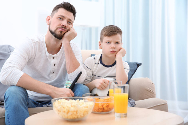 Father and son watching football on TV at home - Photo, Image
