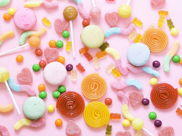 bunte Bonbons und Fruchtgeleesensäfte auf rosa Hintergrund - Foto, Bild