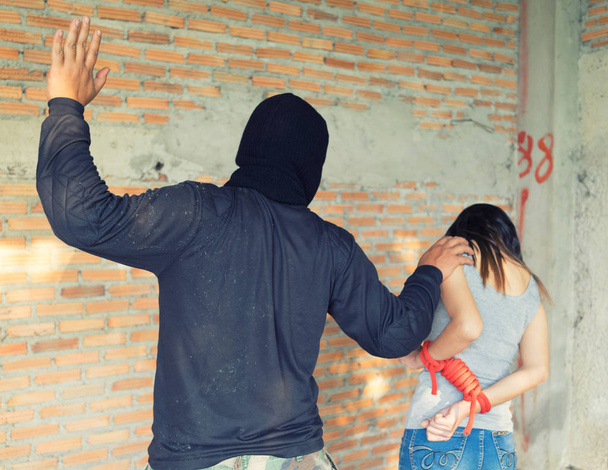 Muž v Balaclavě ohrožuje pistolí ženě - Fotografie, Obrázek