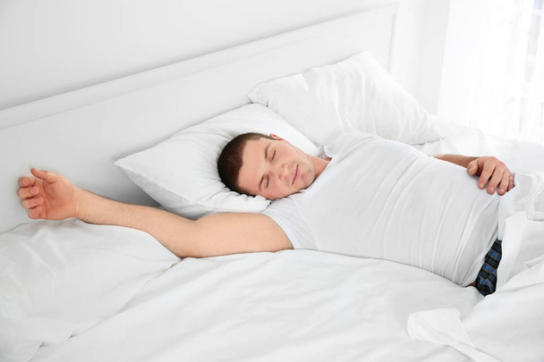 Mladý atraktivní muž spí v posteli doma - Fotografie, Obrázek