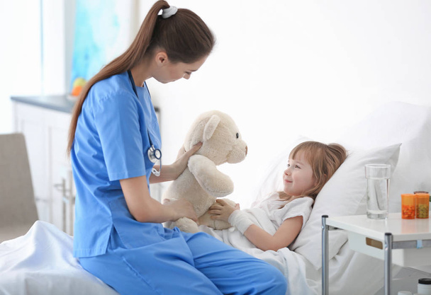 Doctor visiting little girl in hospital room - Фото, изображение