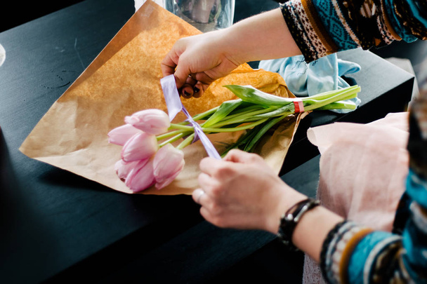 Μικρών επιχειρήσεων. Αρσενικό Ανθοπωλείο χέρια closeup, κόβει τριαντάφυλλο για ανθοδέσμη σε ανθοπωλείο. Ο άνθρωπος βοηθός ή ιδιοκτήτης στο floral σχέδιο studio, κάνοντας τις διακοσμήσεις και τις ρυθμίσεις. Παράδοση λουλουδιών, δημιουργία παραγγελίας - Φωτογραφία, εικόνα