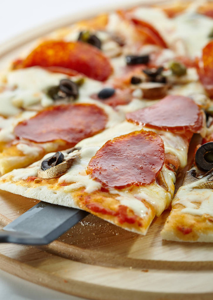 Pizza made with Salami, Mozzarella, Mushrooms, Olives and Tomato Sauce - Фото, зображення