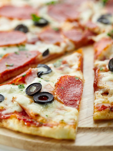 Pizza made with Salami, Mozzarella, Mushrooms, Olives and Tomato Sauce - Foto, Imagen