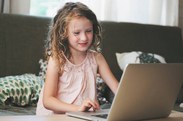happy child using laptop at home. School girl learning with computer and internet indoor. - Φωτογραφία, εικόνα