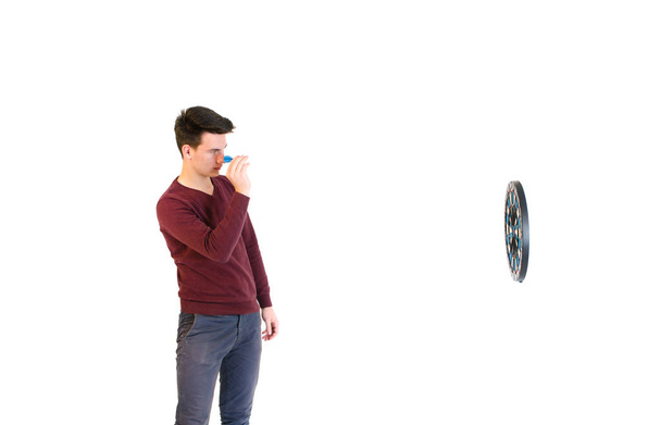 Tinédzser ember visel egy pulóvert, amikor dobott elszigetelt darts játék - Fotó, kép