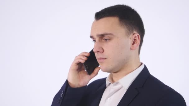Portrait of casual businessman talking on mobile phone. Isolated on white - Felvétel, videó
