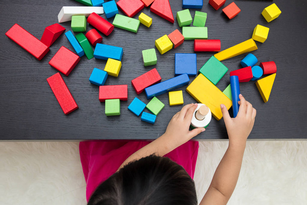 Рука ребенка крупным планом играет строительные блоки
 - Фото, изображение