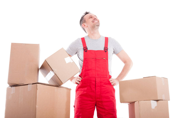 Mover man standing looking up between cardboard boxes - Foto, afbeelding
