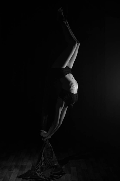 Beautiful silhouette of a girl doing a gymnastic exercise. - Foto, afbeelding