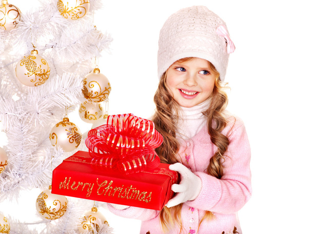 παιδί σε καπέλο και γάντια που κατέχουν κόκκινο δώρου Χριστουγέννων . - Φωτογραφία, εικόνα