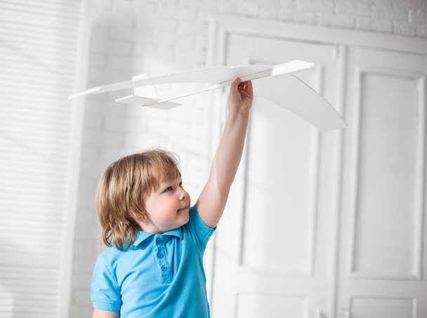 счастливый мальчик играет с самолетом в руках, ребенок мечтает о нем
 - Фото, изображение