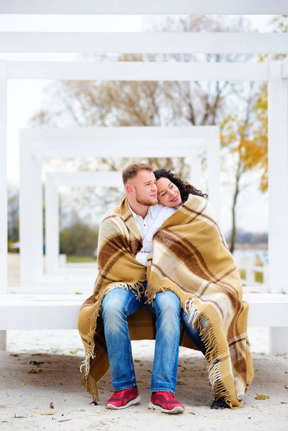 Giovane coppia che abbraccia e coperto con una coperta calda seduta o
 - Foto, immagini