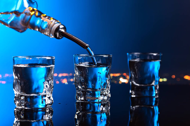 wodka in een staaf op een zwarte achtergrond - Foto, afbeelding