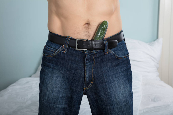 Closeup Of A Person With A Cucumber Stuffed Down His Pants At Home - Foto, afbeelding