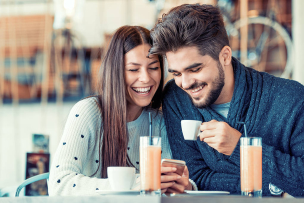 Happy νεαρό ζευγάρι διασκεδάζοντας στο καφέ - Φωτογραφία, εικόνα