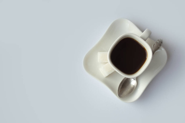 White cup for coffee on a plate with shugar cubes - Fotoğraf, Görsel
