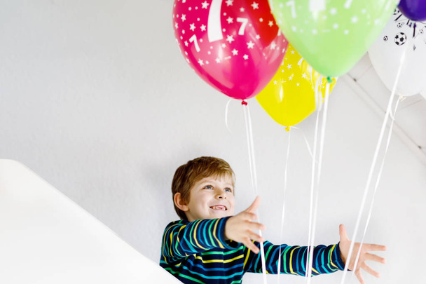 Portrait of happy kid boy with bunch on colorful air balloons on 7 birthday - Foto, Imagen