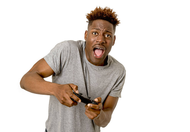  Afro Amerikaanse man met behulp van afstandsbediening afspelen van video game blij en opgewonden  - Foto, afbeelding