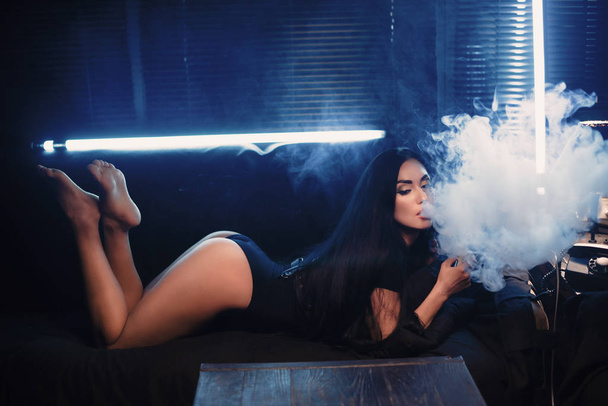κάπνισμα vape mod σε μια σέξι τρόπο, γυναίκα στον καναπέ, vape έννοια - Φωτογραφία, εικόνα
