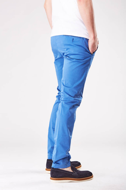 Man is posing in light studio in trendy blue chinos and black shoes - Foto, imagen