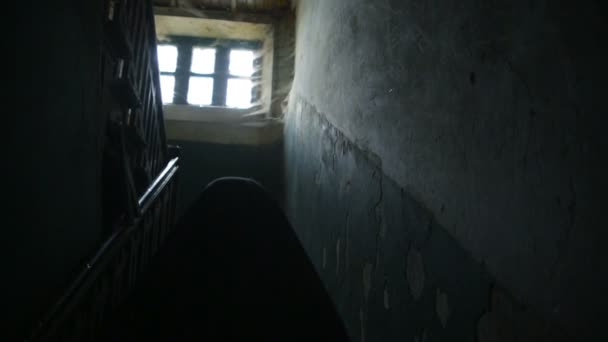ein Mann in schwarzem Kapuzenpulli mit Kapuze in einem schrecklichen alten Haus mit Spinnweben. - Filmmaterial, Video