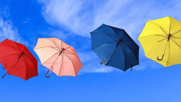 Värikkäät sateenvarjot lentävät siniselle taivaalle
 - Valokuva, kuva
