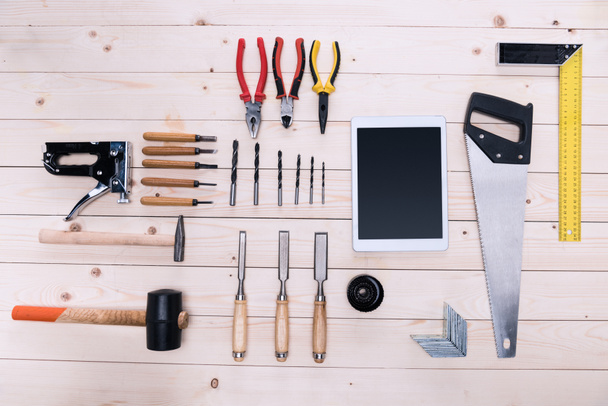 Top view of various construction tools and digital tablet on wooden table - Foto, Imagem