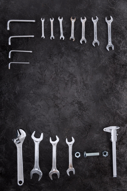 Bauwerkzeug, Schraubenschlüssel und Schlüsselanhänger auf schwarz - Foto, Bild