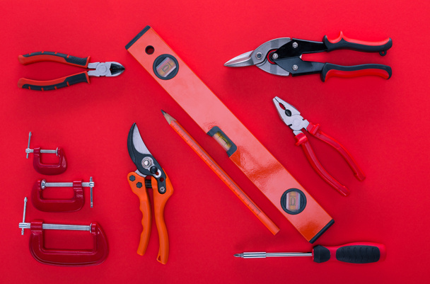 top view of various work tools and pencil on red - Photo, Image
