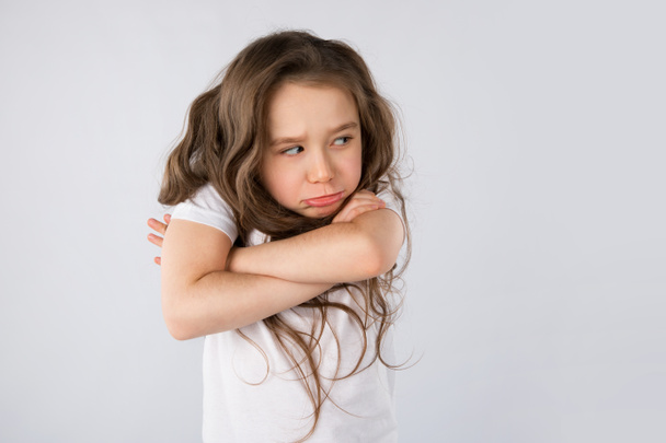 Porträt eines wütenden und traurigen kleinen Mädchens isoliert auf weißem Hintergrund - Foto, Bild