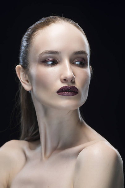 portrait of the young woman with a dark lips and classic make-up isolated on a black background - 写真・画像