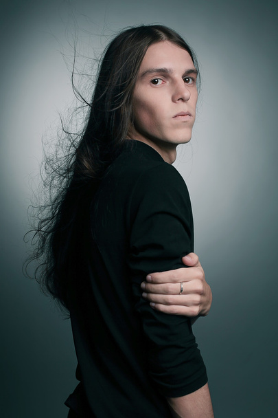 Arty portrait of a fashionable male model with long hair over da - Foto, imagen