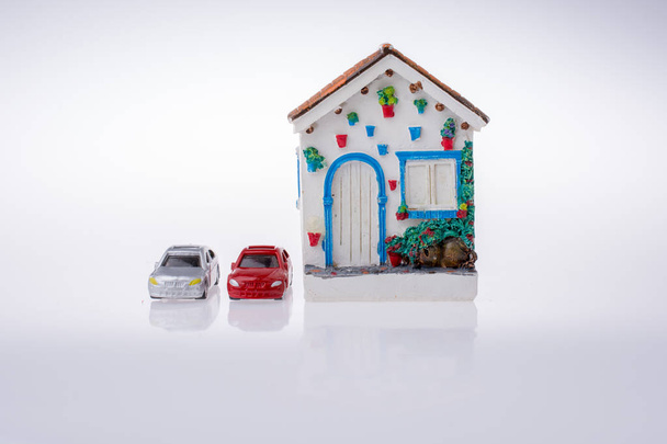 Маленький модельный дом и модели автомобилей
 - Фото, изображение