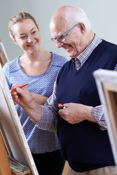 Senior Man Attending Painting Class With Teacher - Foto, imagen