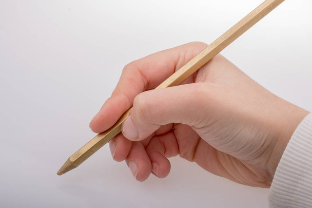 Χέρι που κρατά ένα χρυσό χρώμα μολύβι στο χέρι - Φωτογραφία, εικόνα
