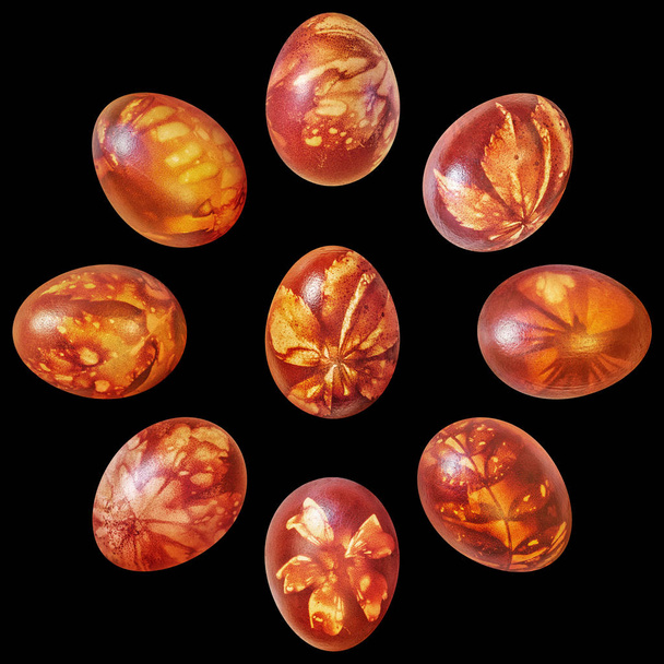 Devět červené velikonoční vejce cibule kůže barvená a zdobené listy otisky izolované na černém pozadí - Fotografie, Obrázek
