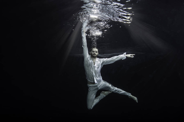 Un jeune danseur de ballet masculin posant sous l'eau
 - Photo, image